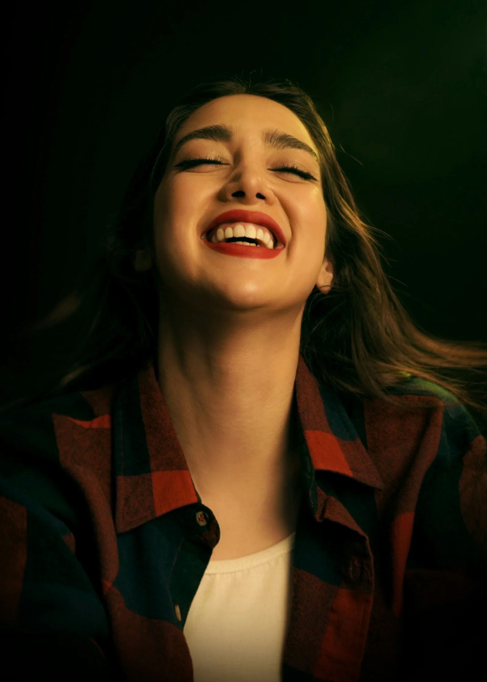 a woman smiling and laughing with her eyes closed