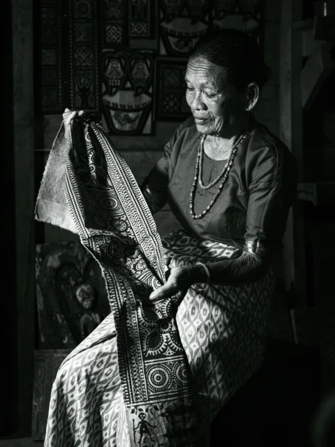 A black and white photo of a woman sitting in a chair