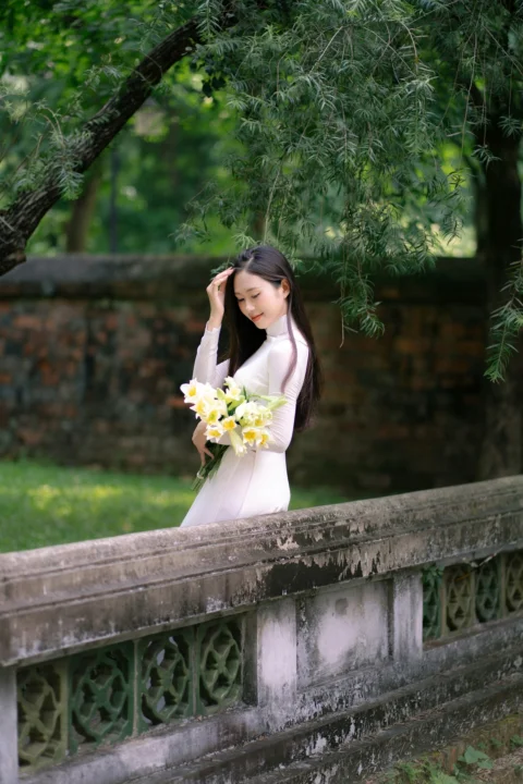 A young woman holds flowers outdoors