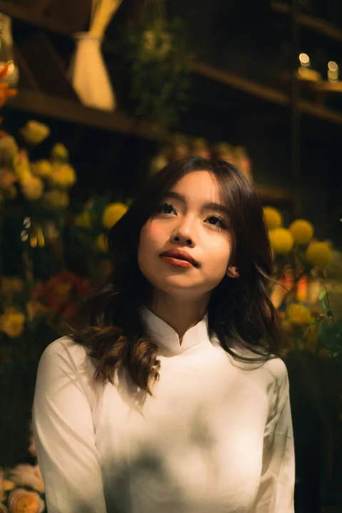一名女人站在一束花前