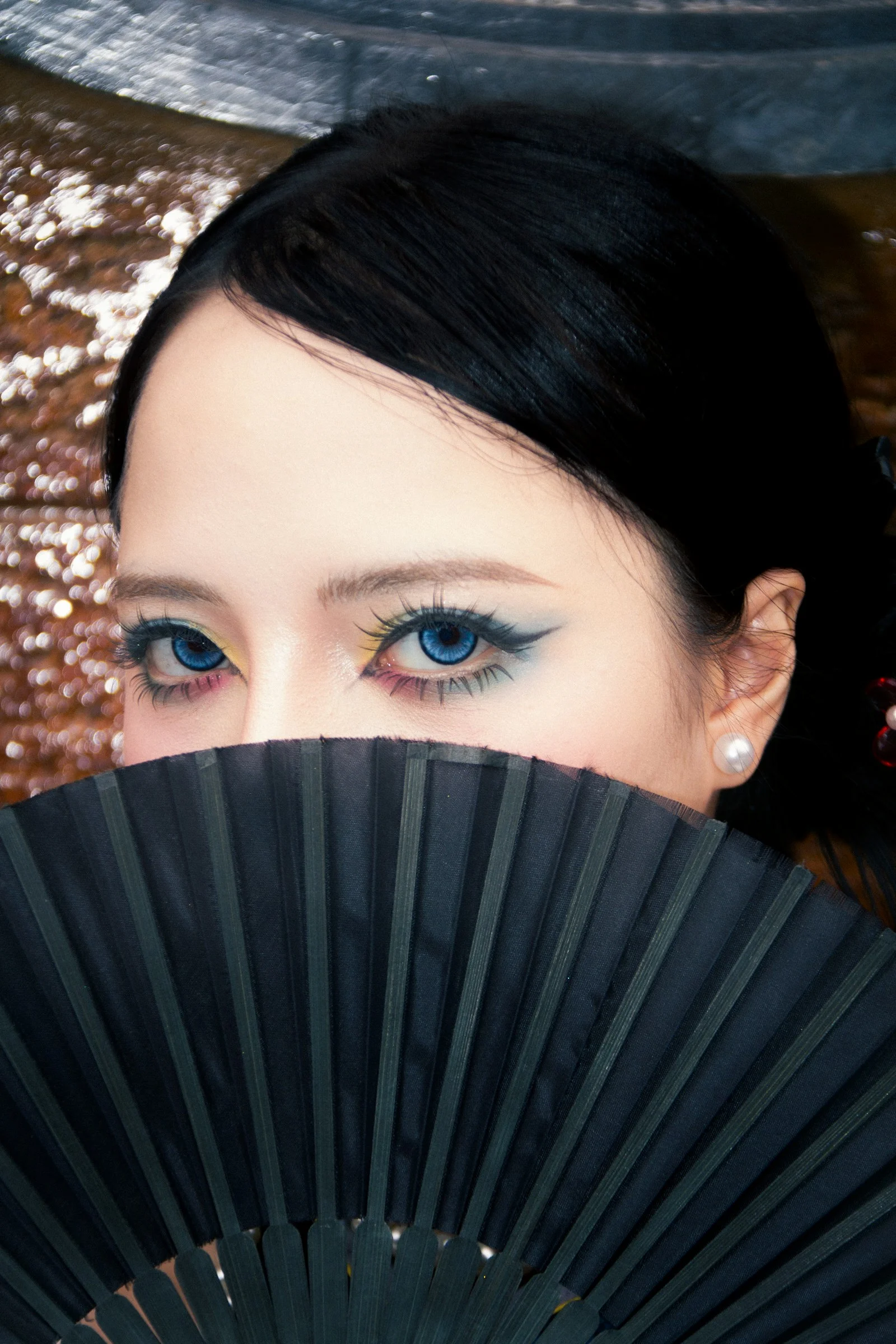 蓝眼睛的女人手持一把黑色扇子