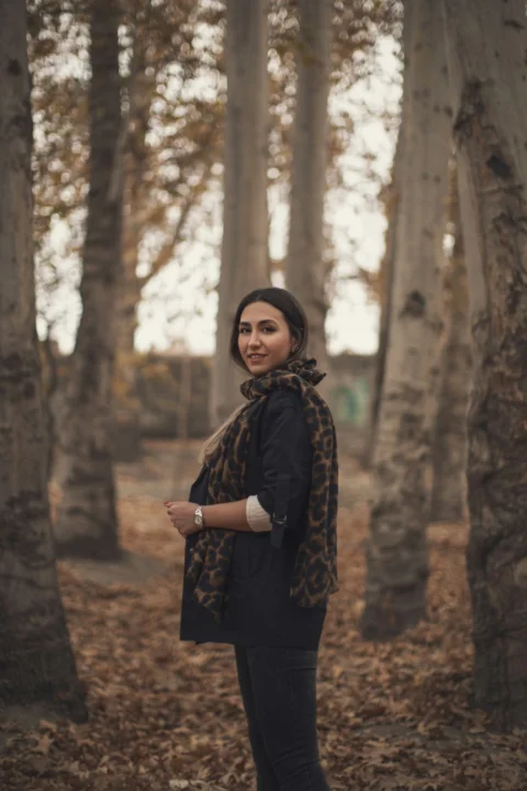 a woman standing in the middle of a forest