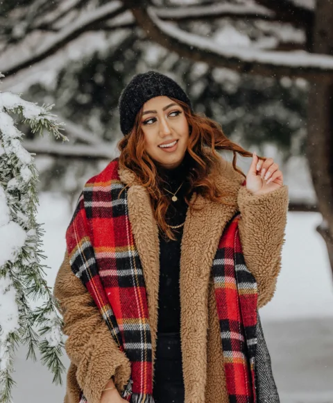 戴着格纹围巾站在雪地里的女子