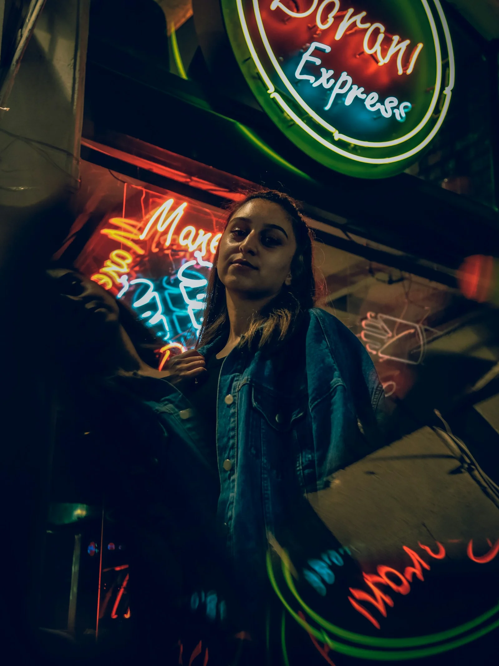 a woman standing in front of a neon sign