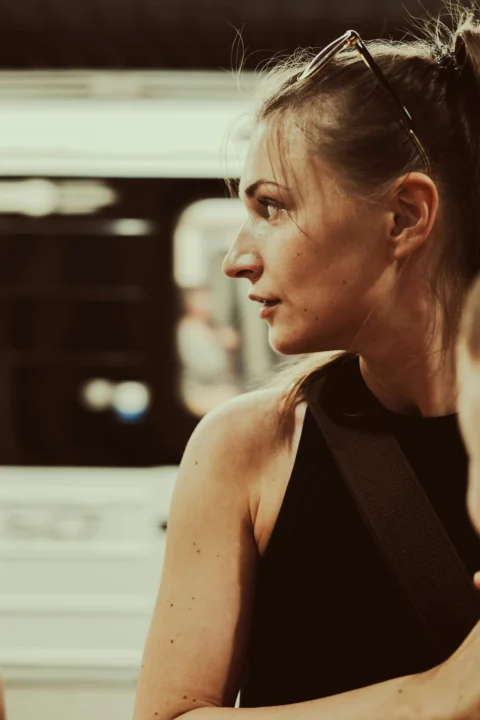 a woman in a black top and a train in the background