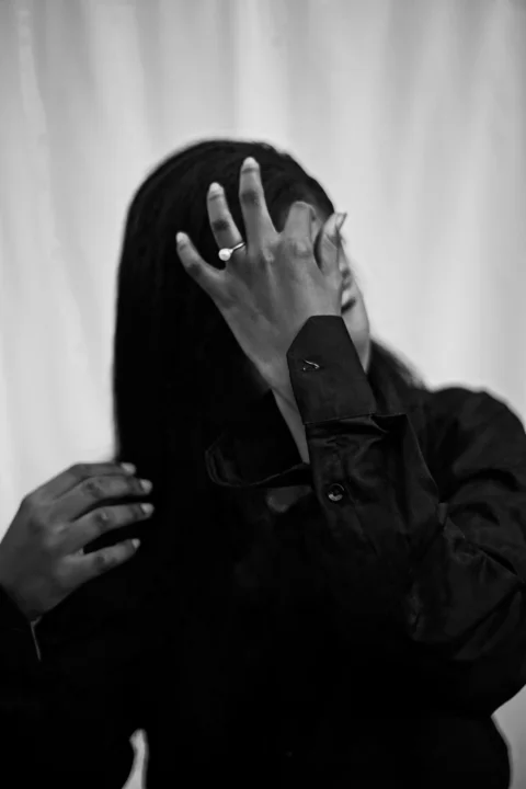 A woman covers her face with her hand