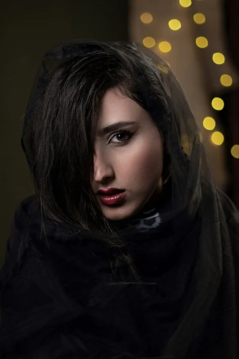 A woman with dark hair and red lipstick wearing black