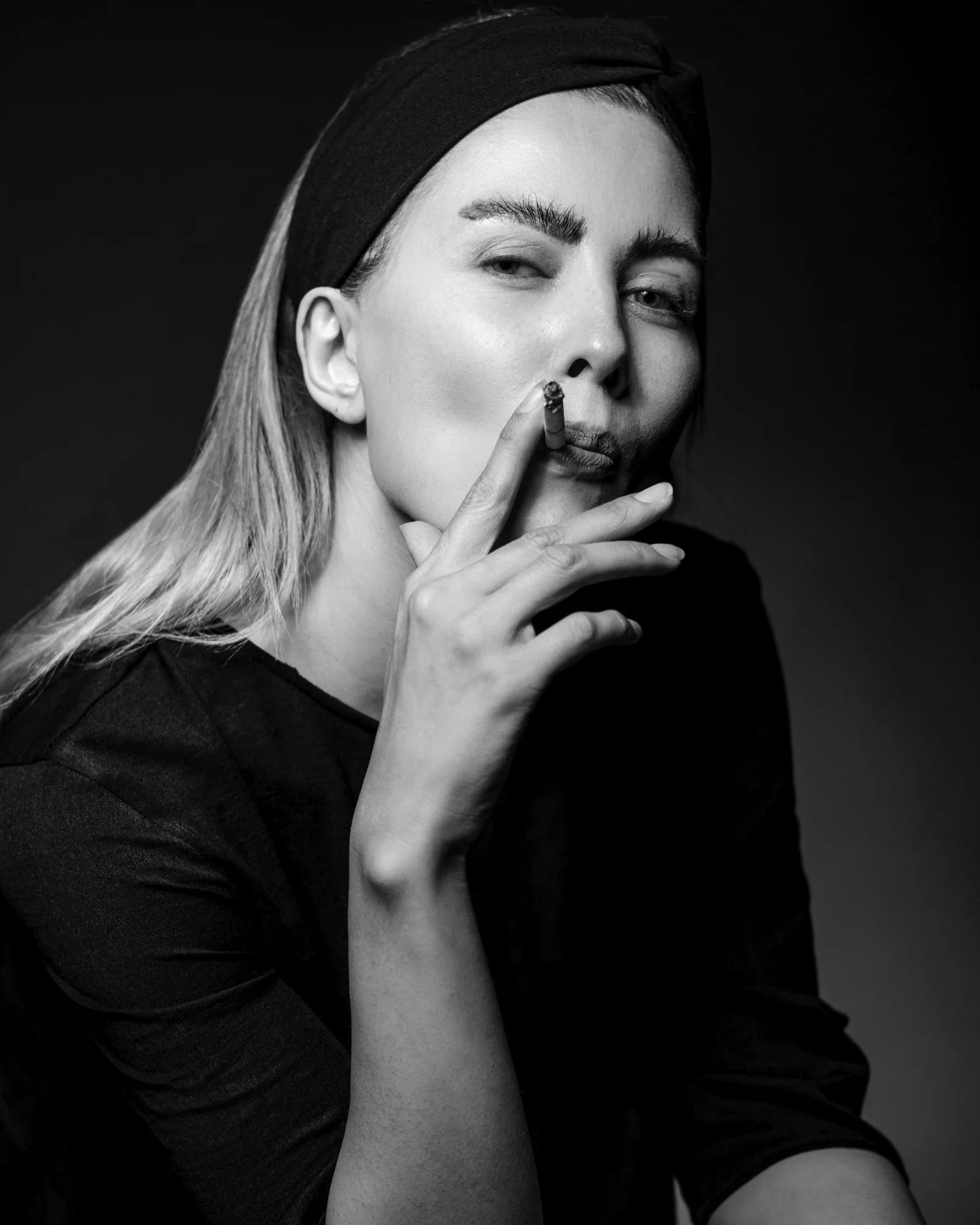 a woman with her eyes closed and her hand on her mouth