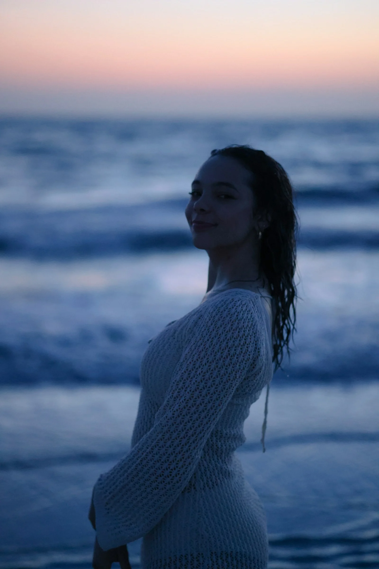 黄昏时分一名女子在海滩上微笑