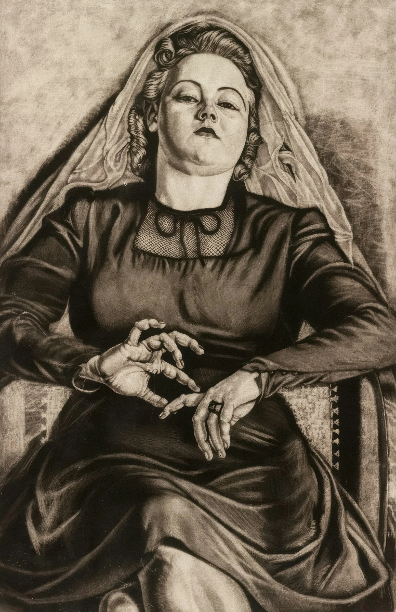 Woman in dark dress with veil sits with hands clasped