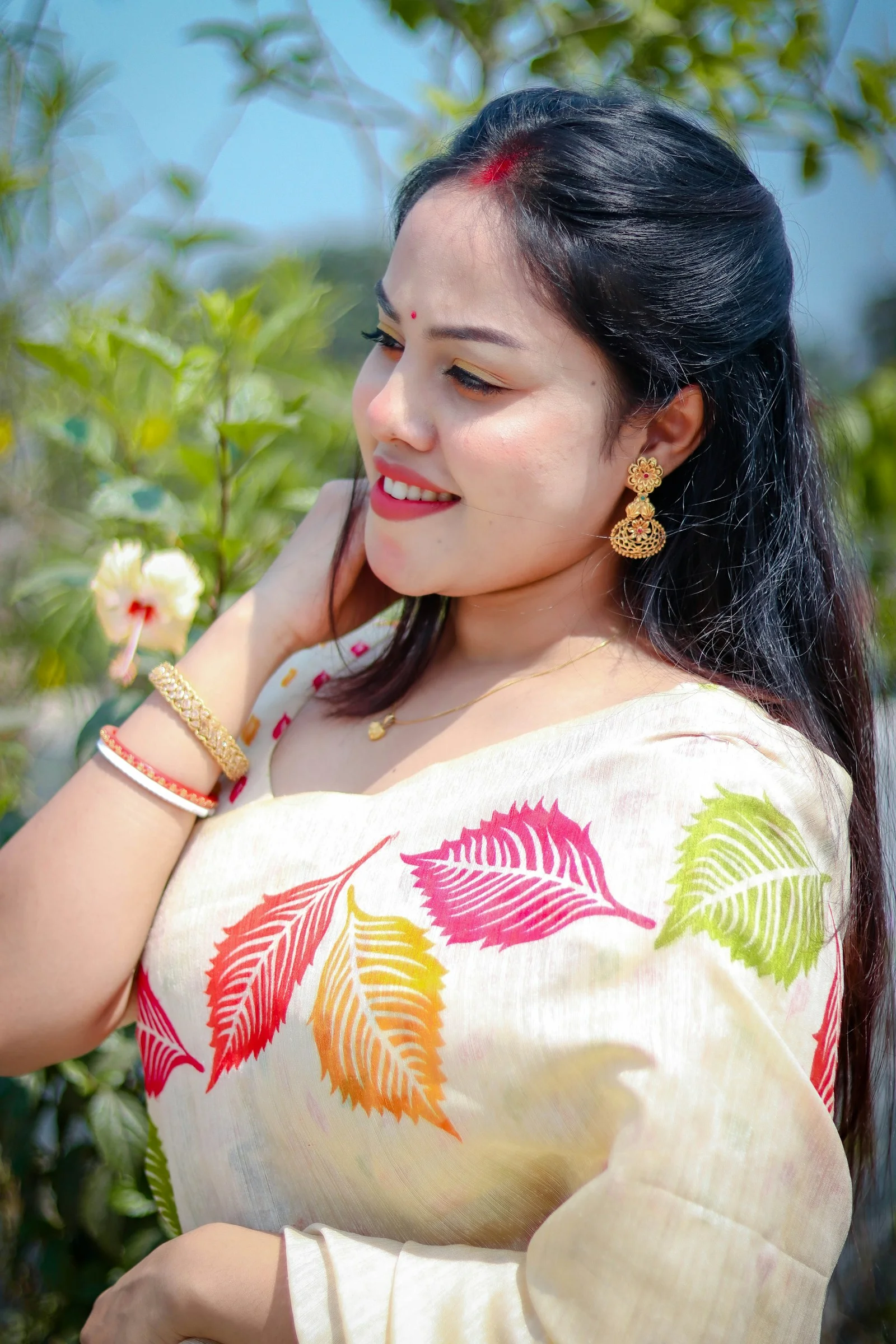 A smiling woman wears a sari