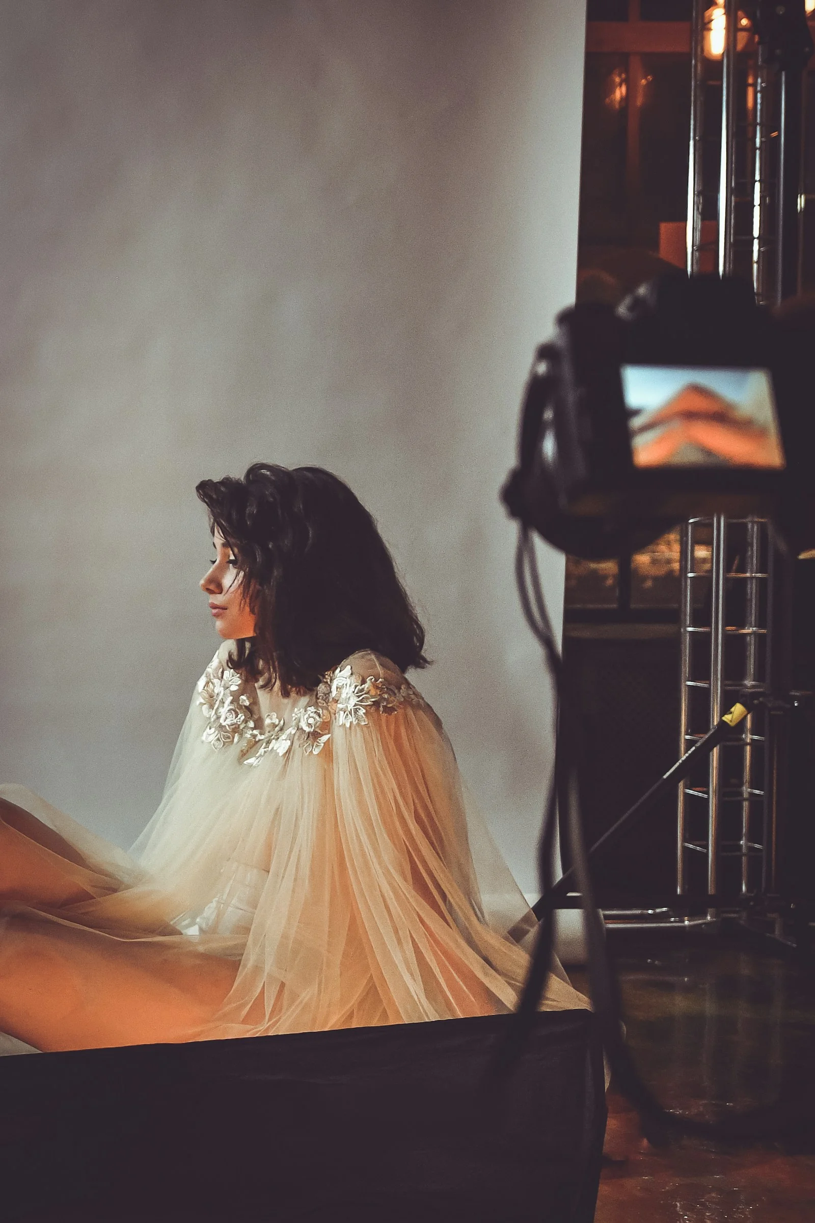 sitting woman wearing white lace dress with white background