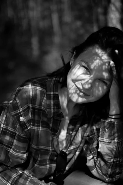 Woman's face is dappled with sunlight