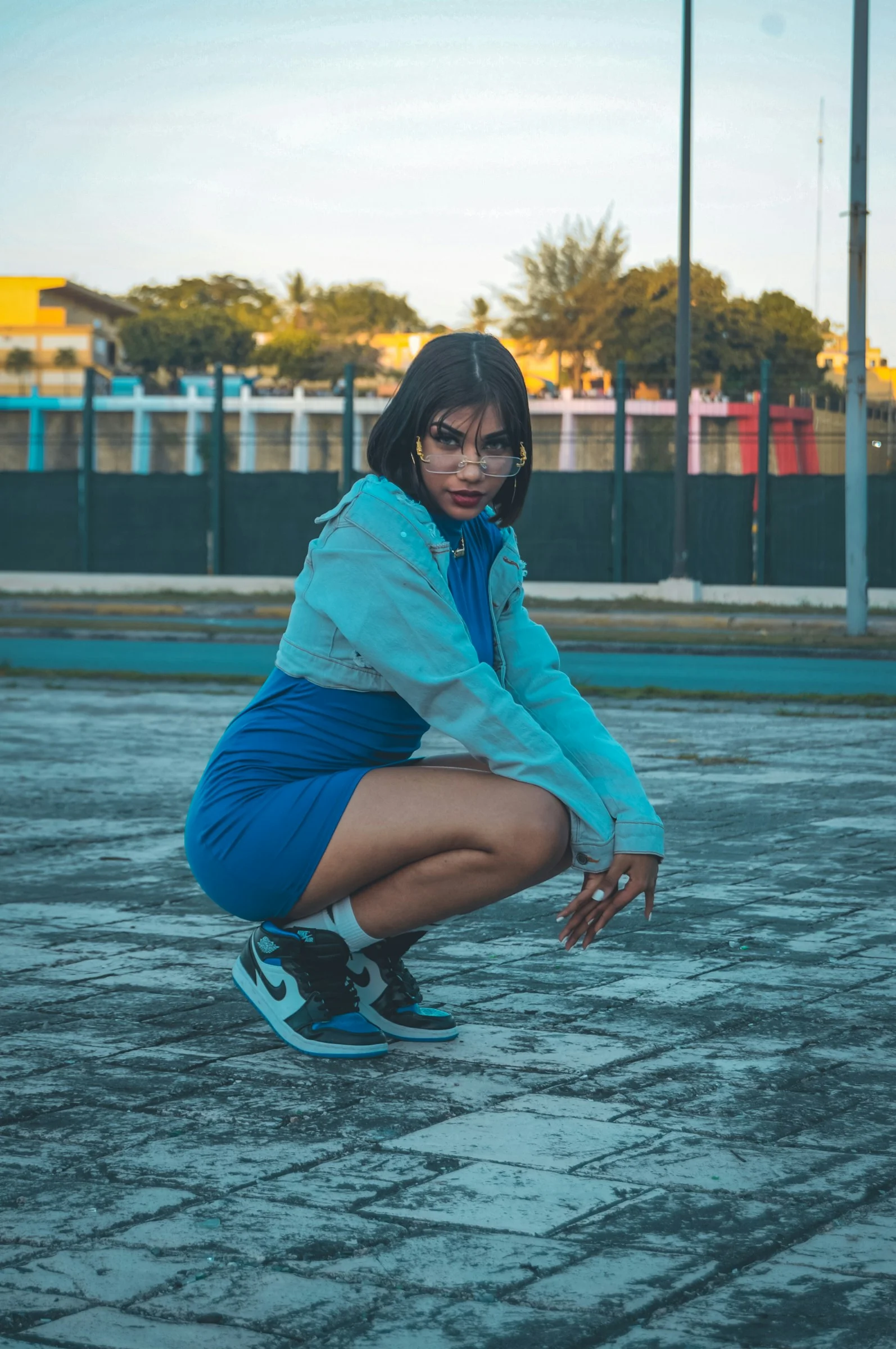 a woman squatting down in a parking lot