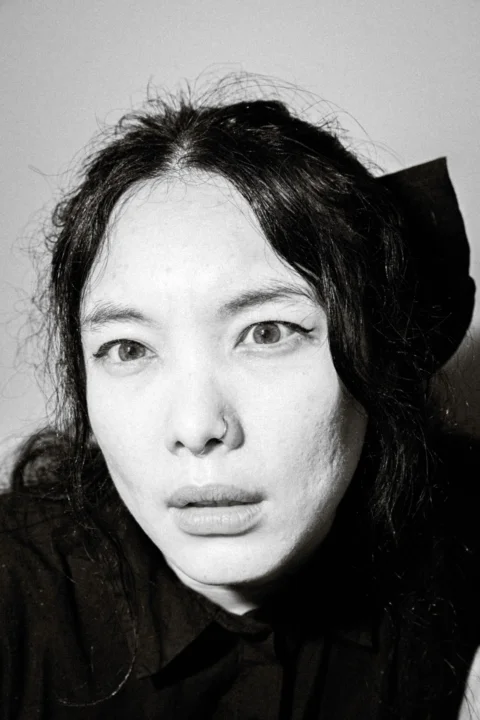 a black and white photo of a woman wearing a black shirt