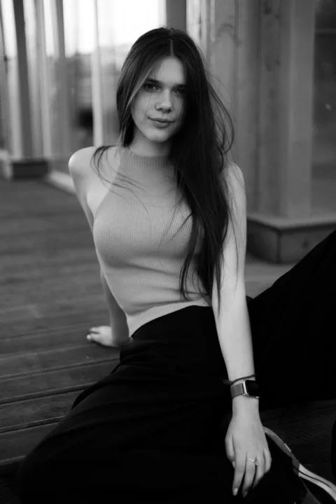 A young woman poses gracefully in black and white