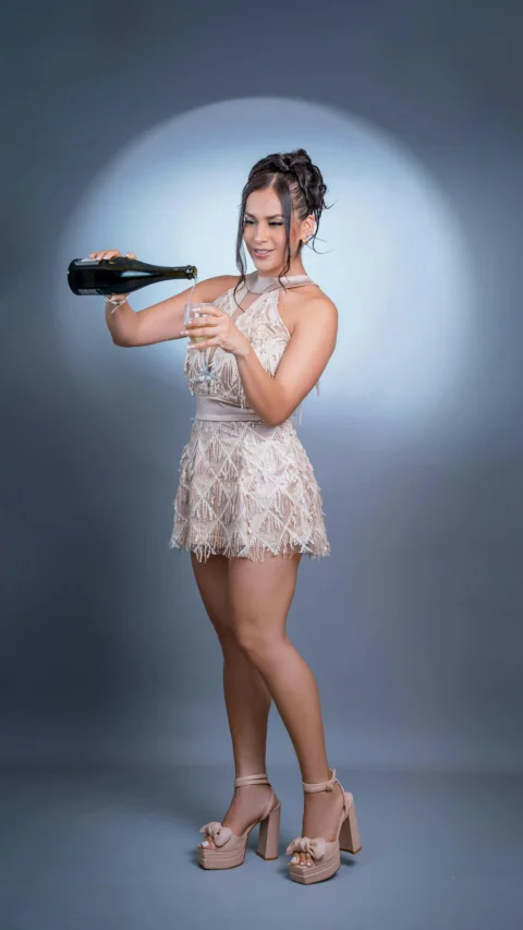 Woman pours champagne into a glass