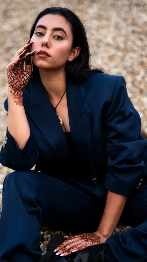 a woman sitting on the ground with her hands on her face