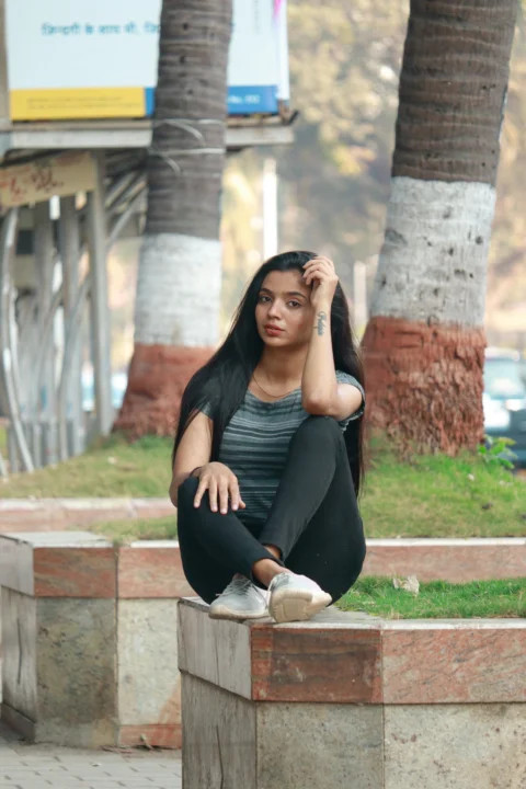 a woman sitting on a block in a park