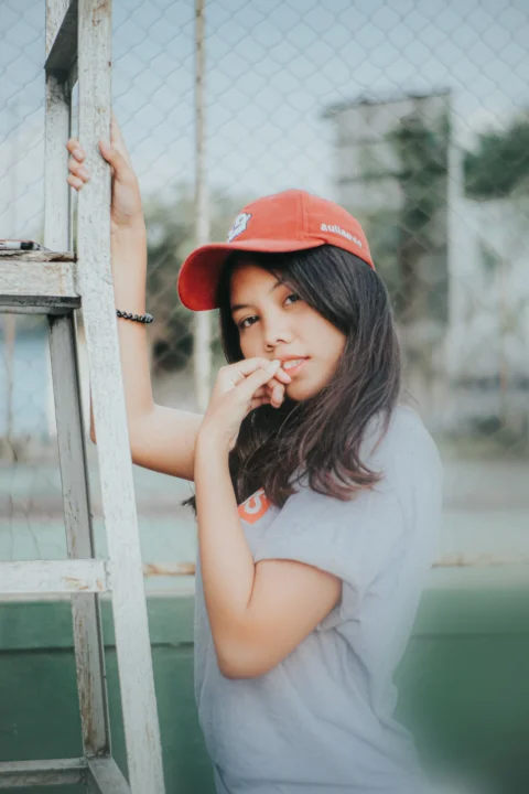 一名戴紅帽的女孩靠在梯子上