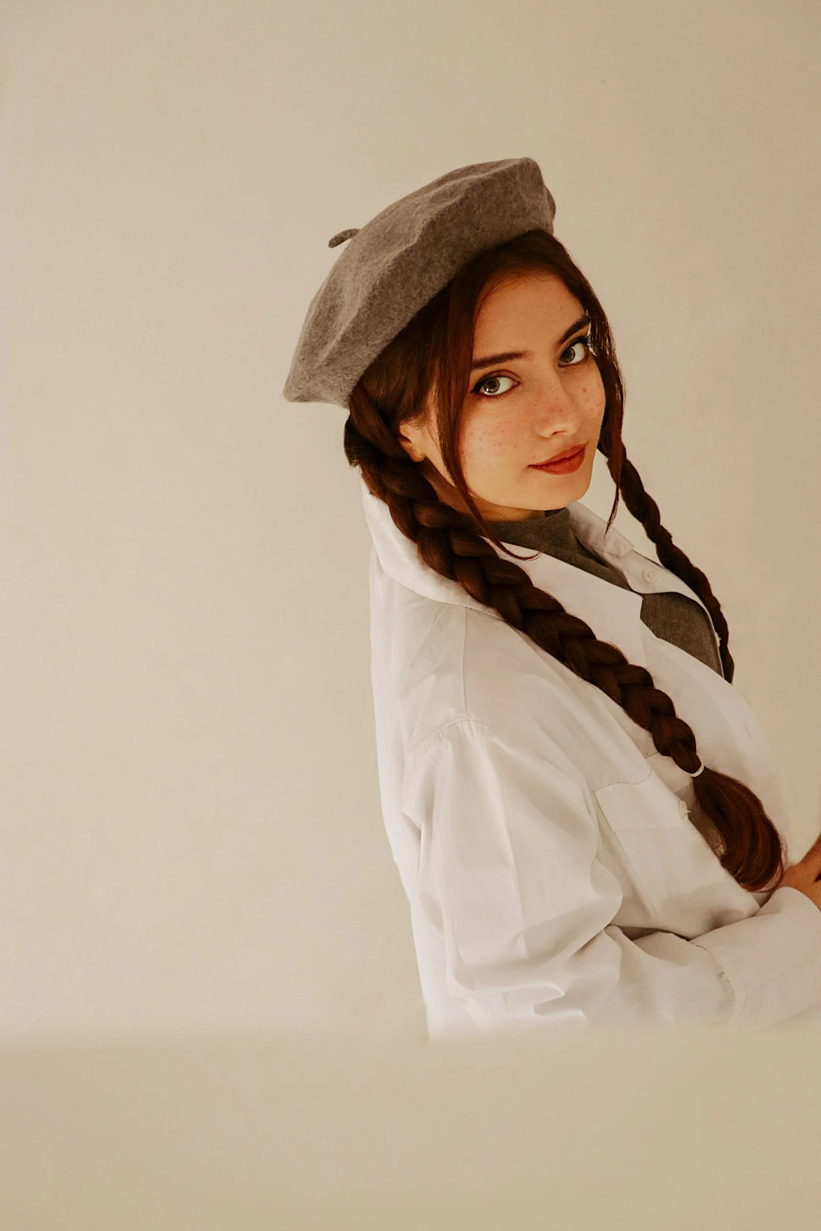 a woman with long braids wearing a hat