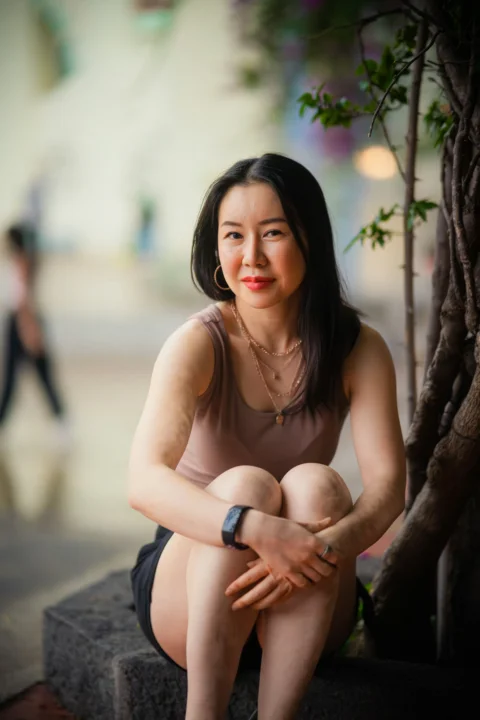 一位女人坐在树旁的长椅上