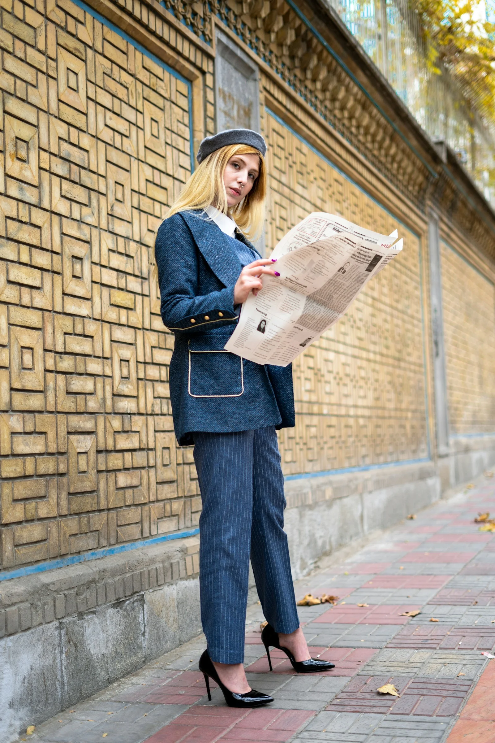 穿西装戴帽子的女人在读报纸