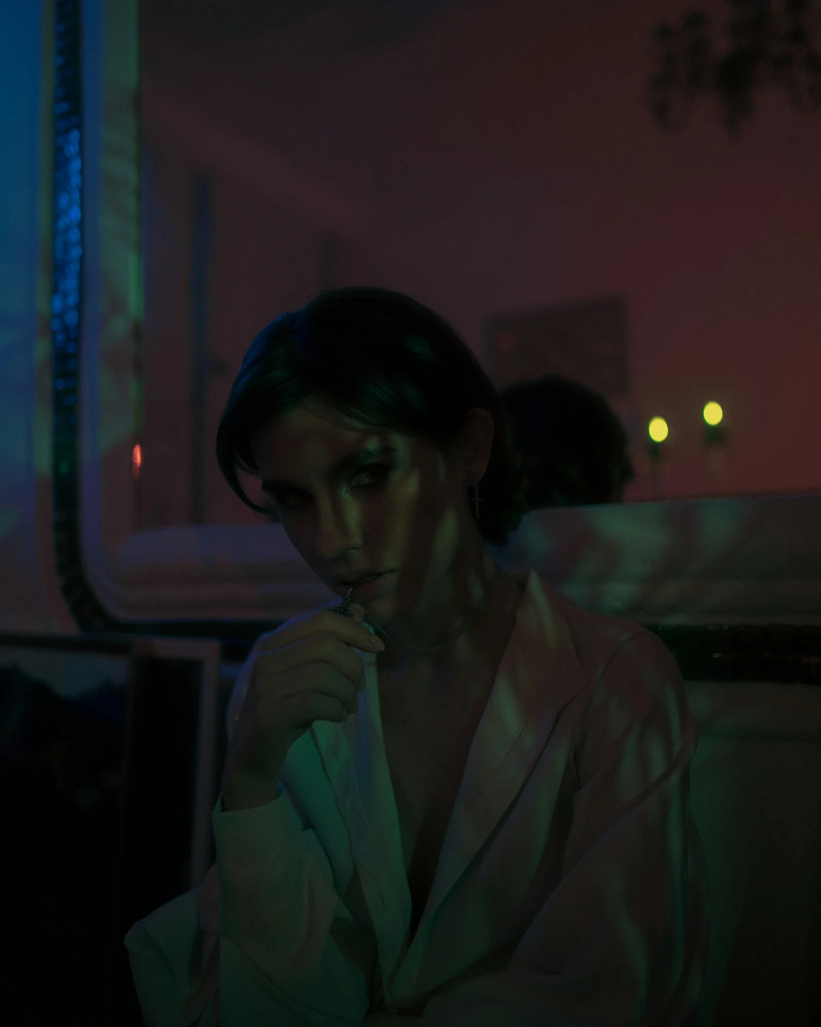 woman in white coat standing near window
