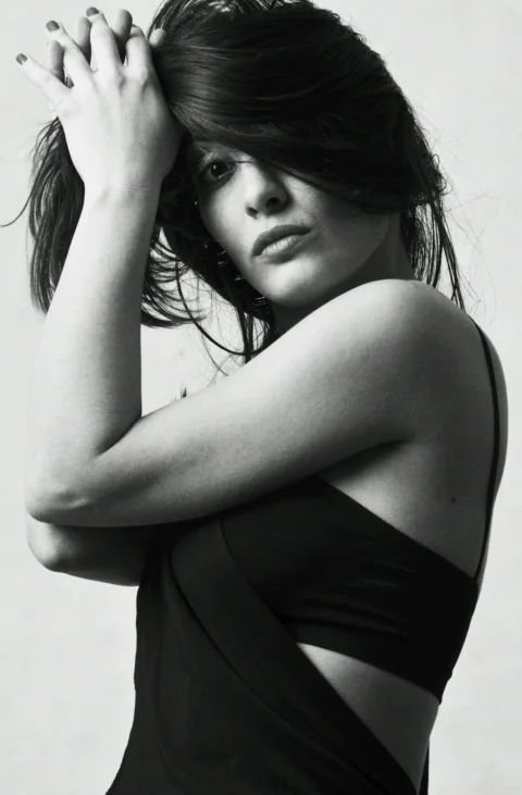 A black and white photo of a woman with her hands on her head