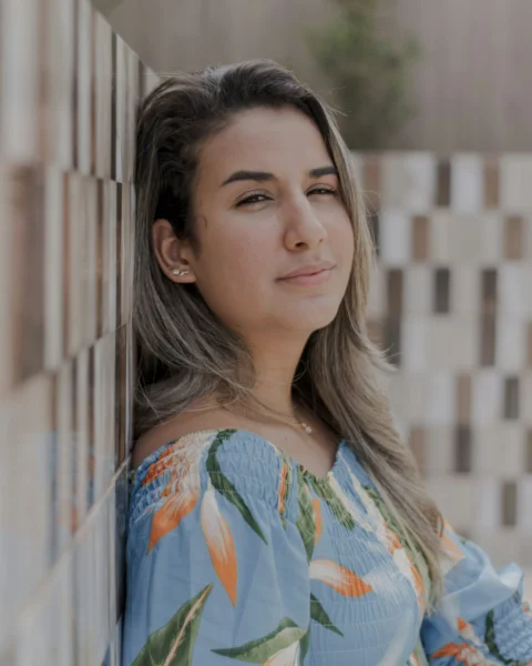 a woman leaning against a wall with her eyes closed