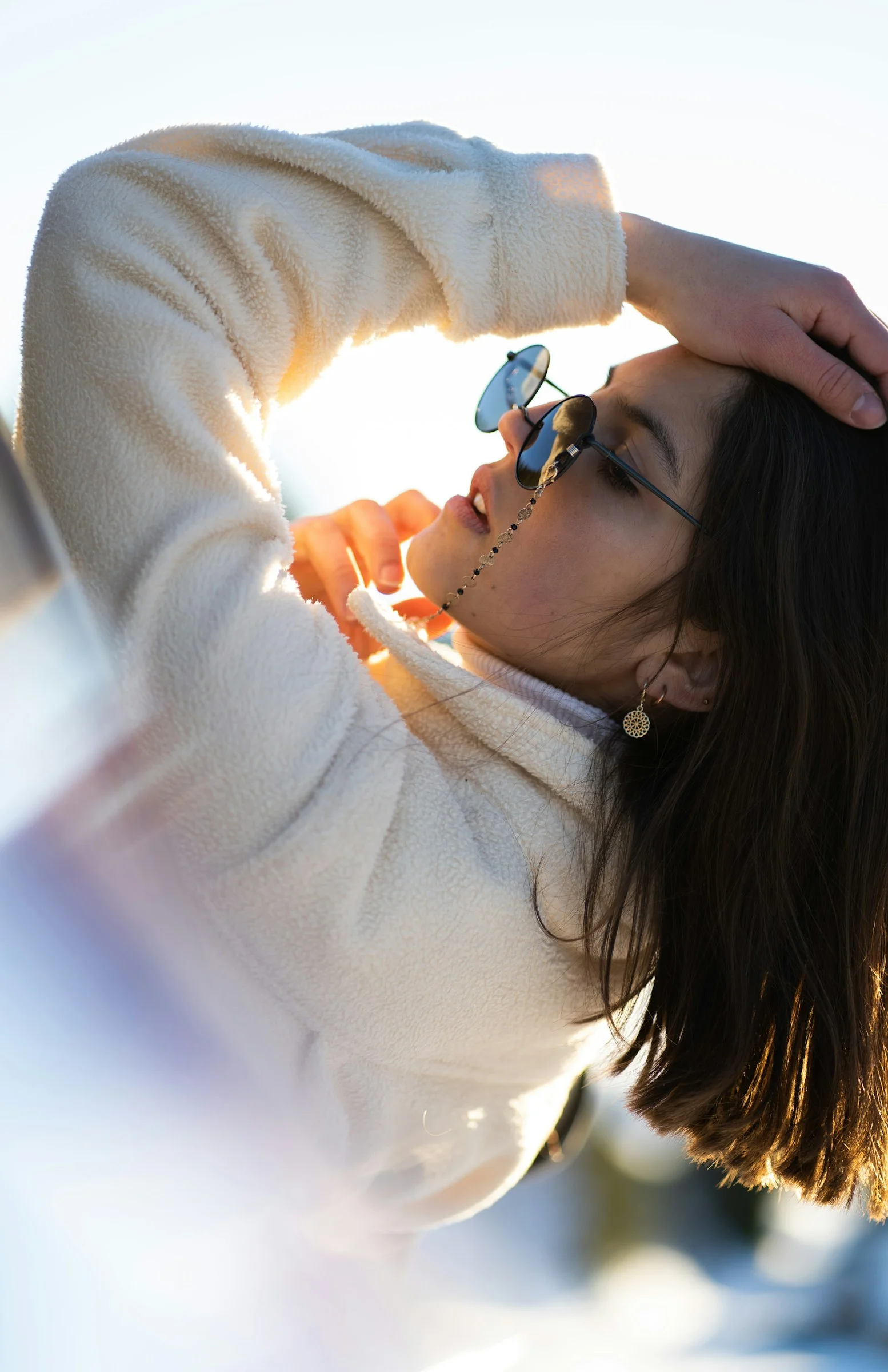 a woman in a white sweater and sunglasses
