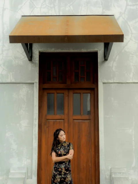 a woman standing in front of a wooden door