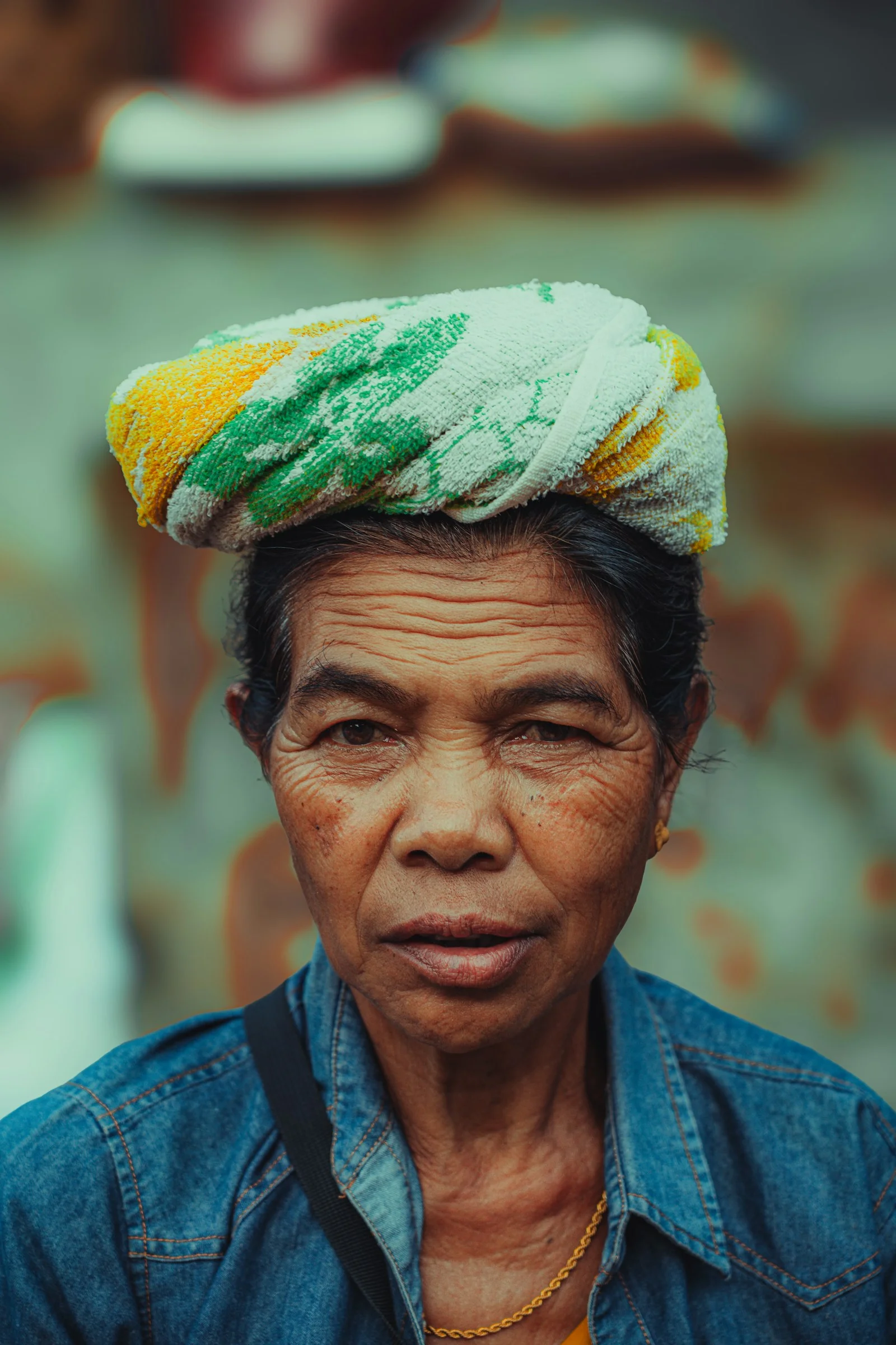 An older woman wears a towel on her head