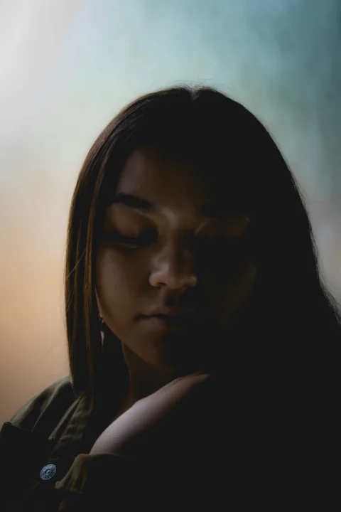 一名女子正低頭看著她的手機