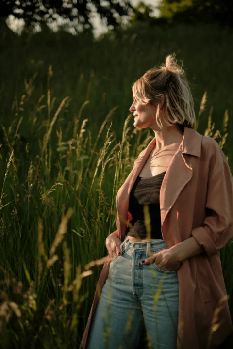 a woman standing in a field of tall grass