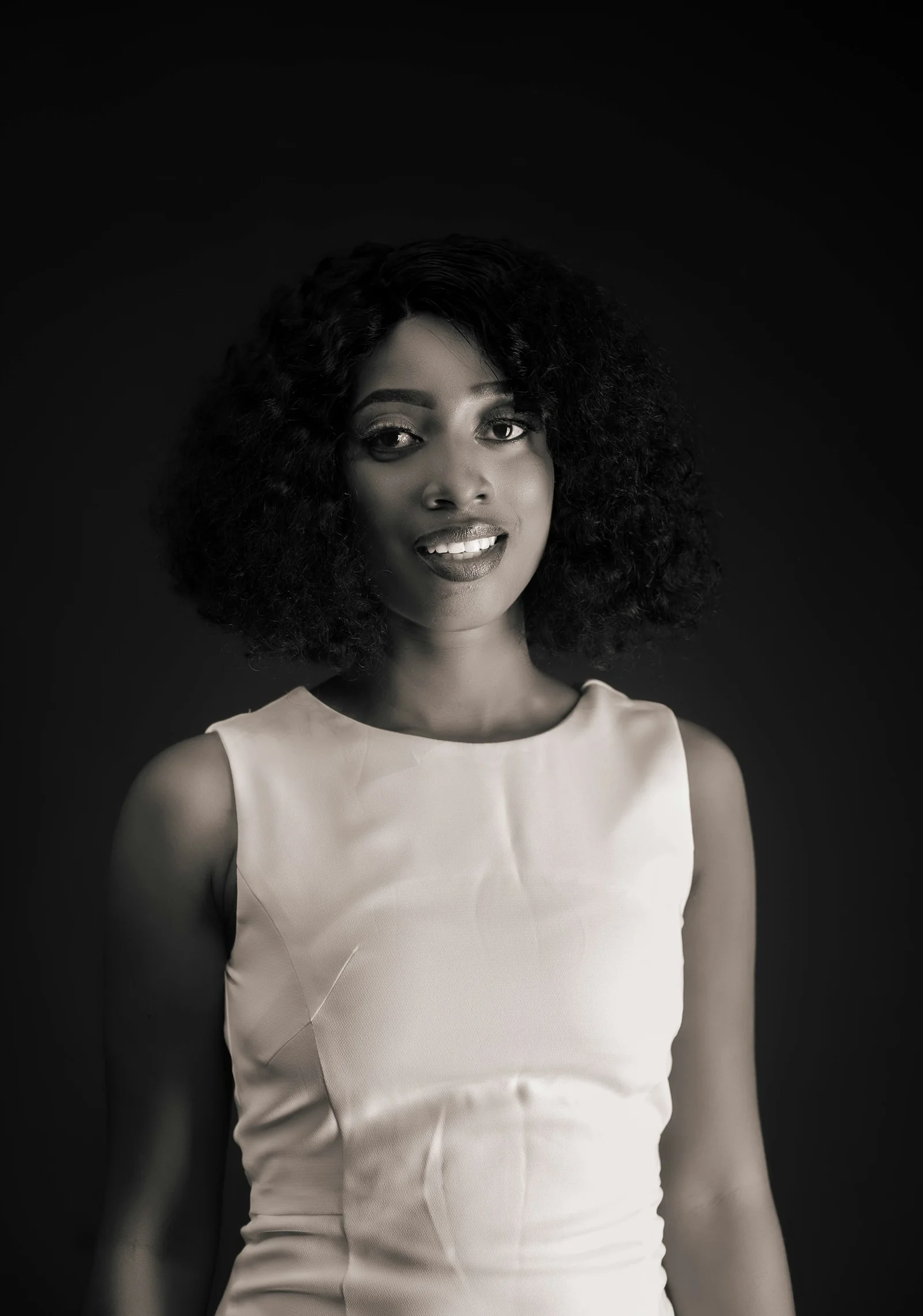 Smiling young woman with curly hair in black and white