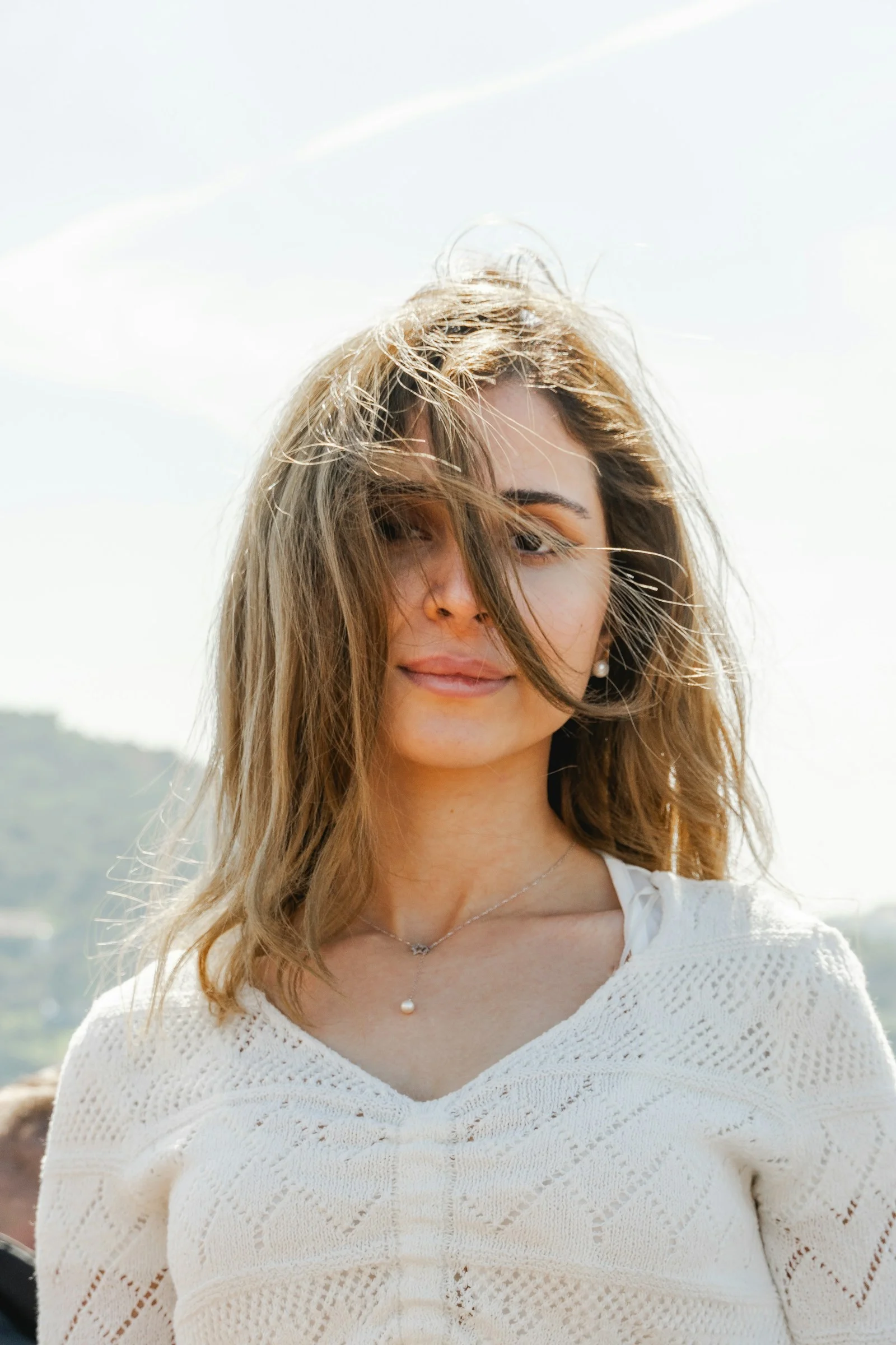 a woman with long hair standing in front of a mountain