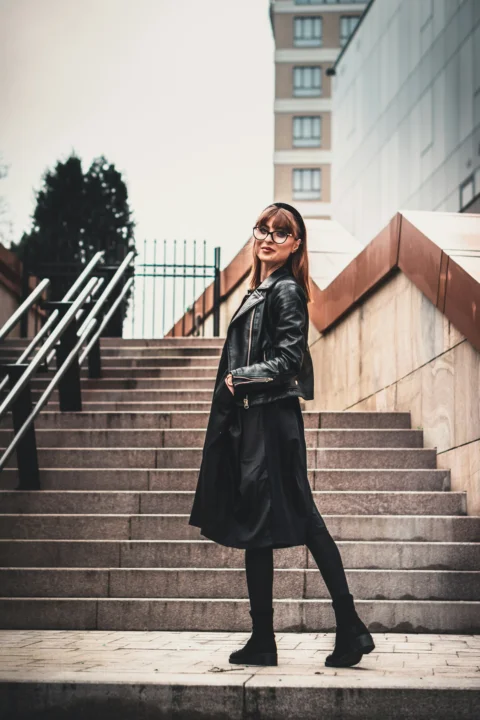 穿黑色皮夾克站在樓梯上的女子