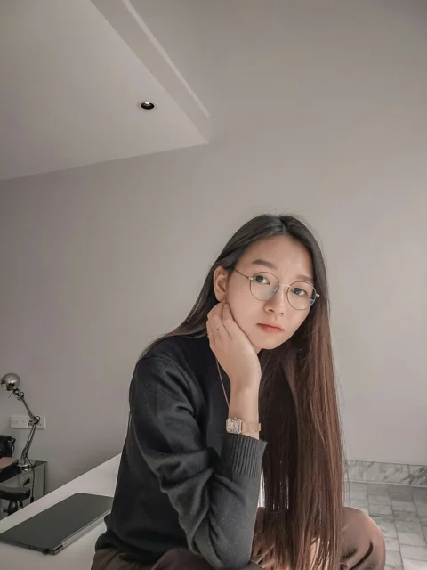 戴眼鏡坐在櫃檯上的女人