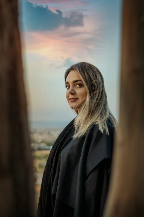 Woman in dark shawl with blonde hair at sunset