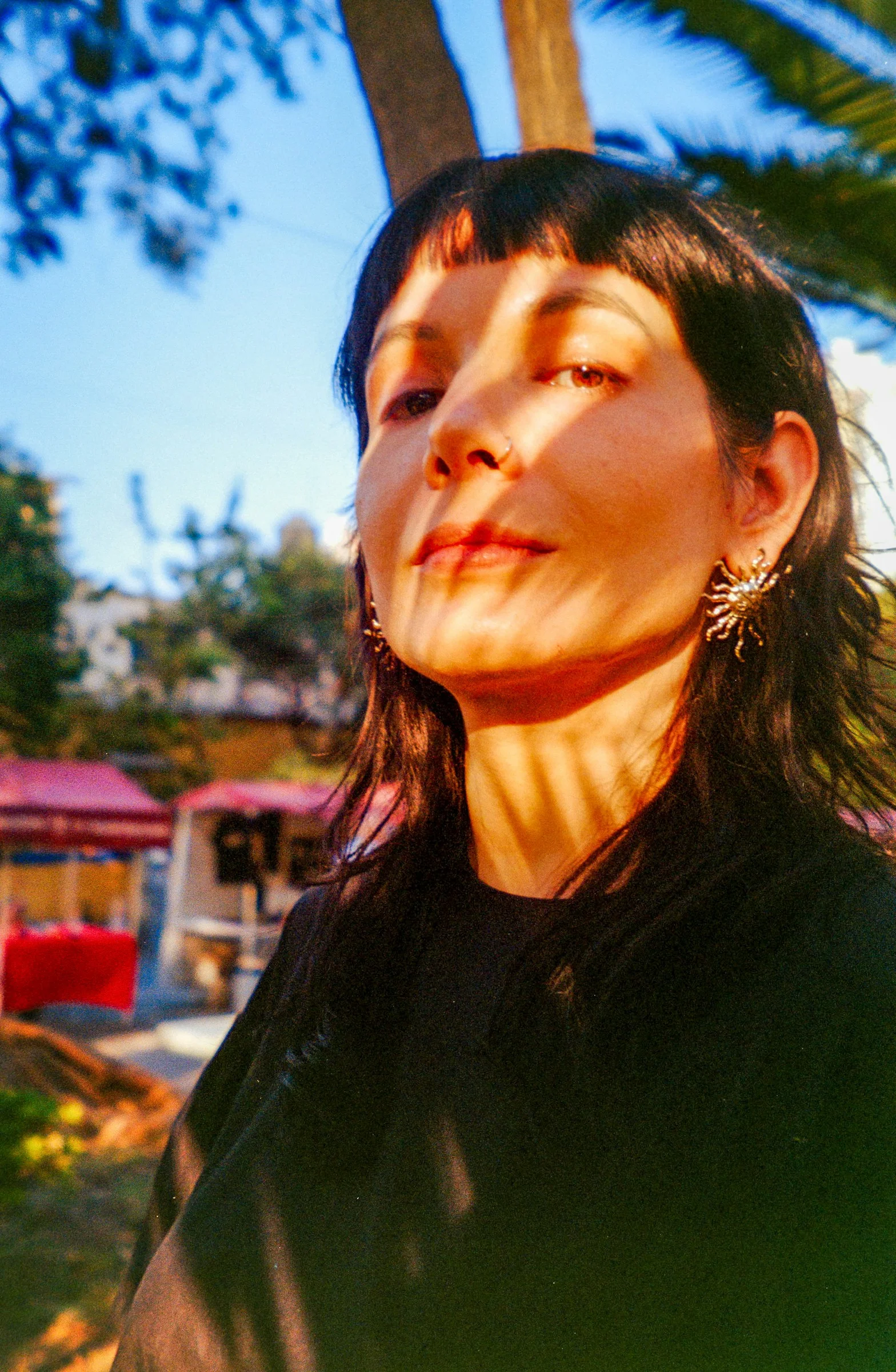 陽光下的女子身上有棕櫚葉的影子