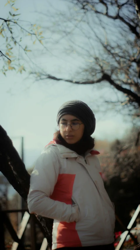 A young woman wearing a hat and glasses outside