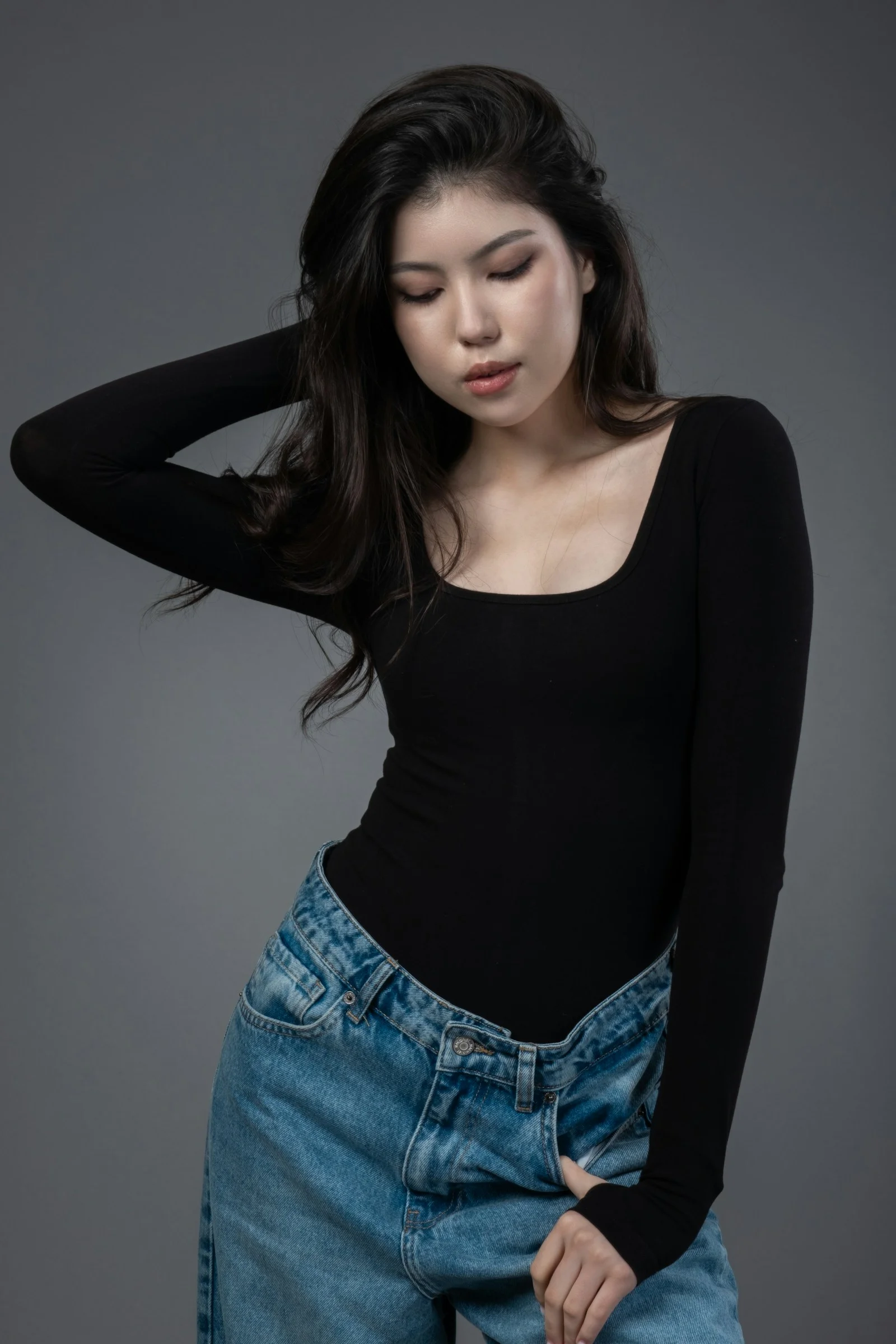 一名穿黑色襯衫和牛仔褲的女子擺姿勢拍照