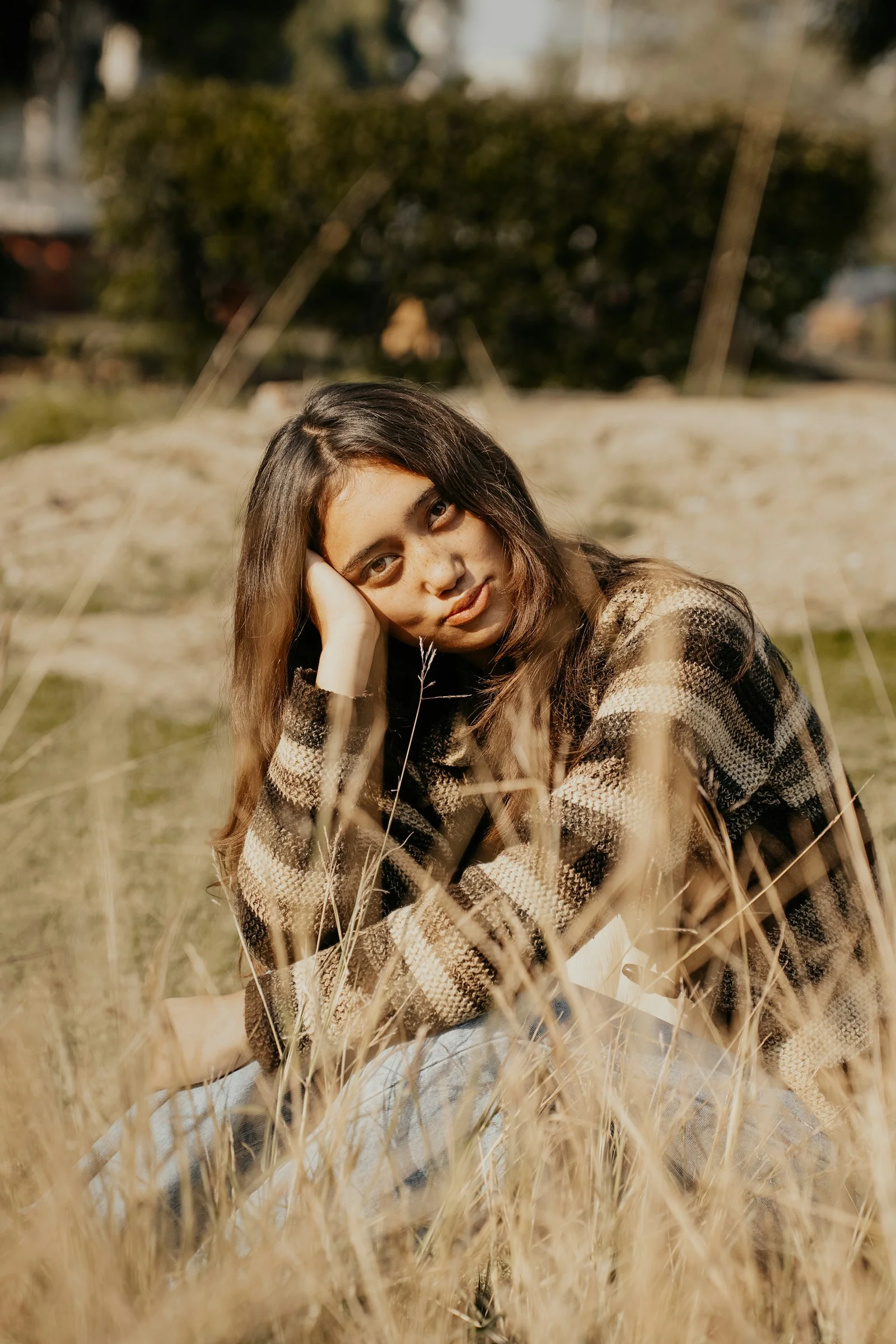 A woman sitting in a field of tall grass