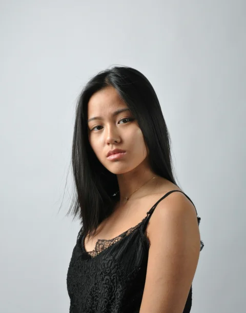 黒いドレスを着たアジア人女性がポーズをとっている写真