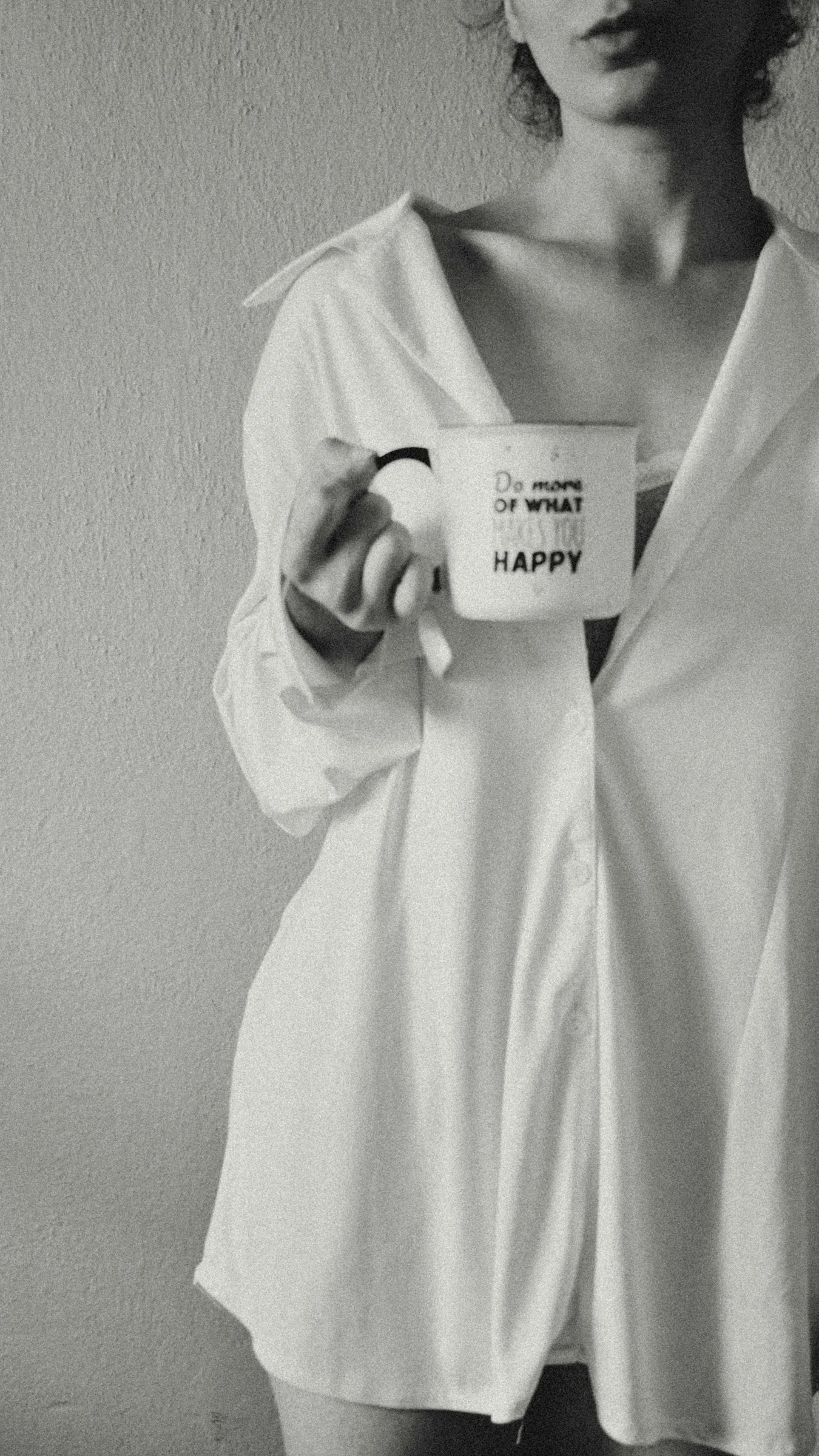 Woman in white shirt holding mug with inspirational quote