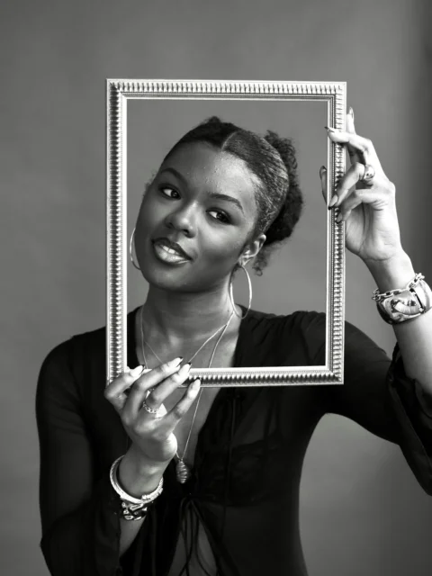 Woman holding a picture frame in front of her face