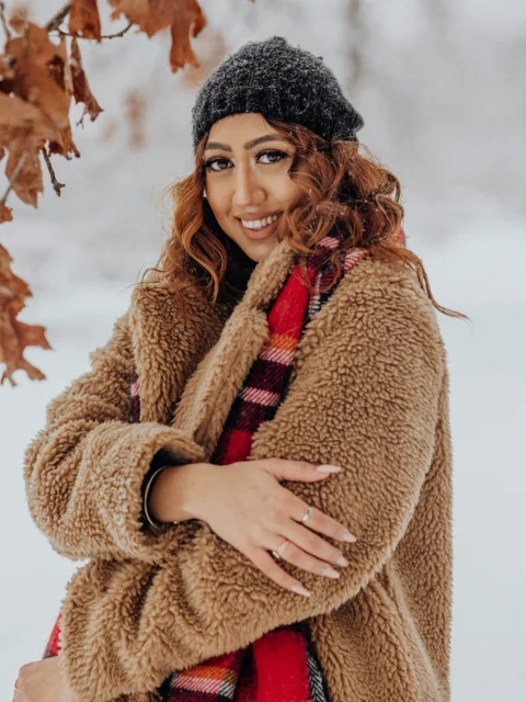 一个双臂交叉站在雪中的女人