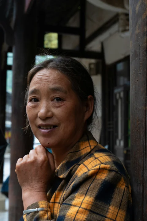 一位女子站在人行道的立杆旁