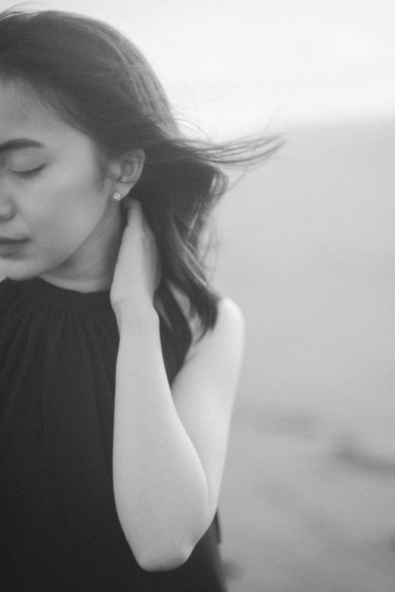 風になびく髪の女性の白黒写真